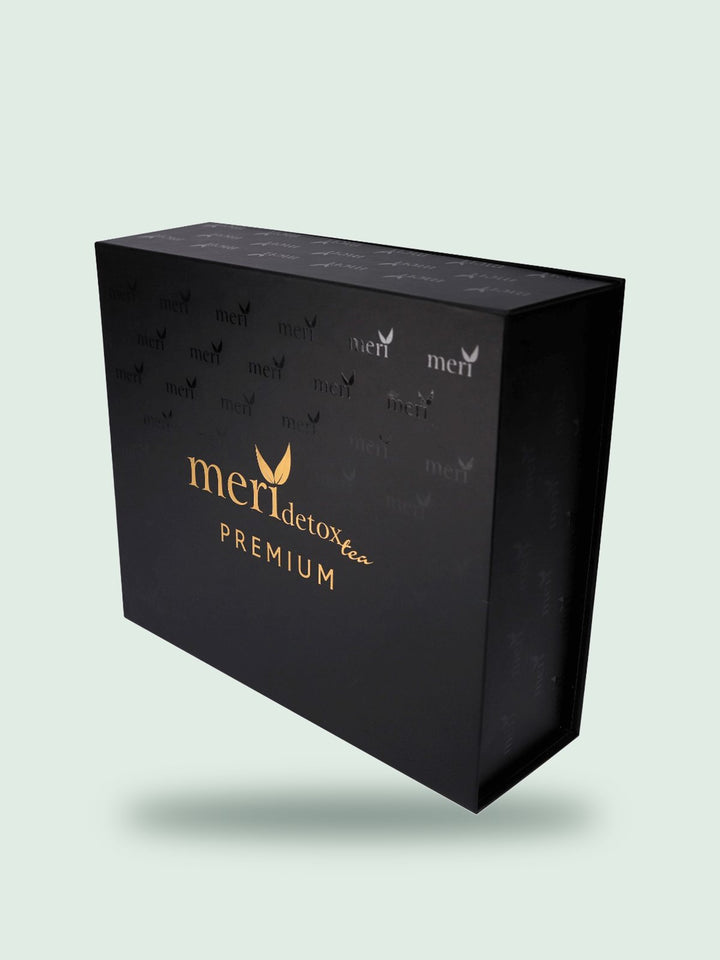 Black and gold Meri Detox Tea Premium box, on a soft sage background